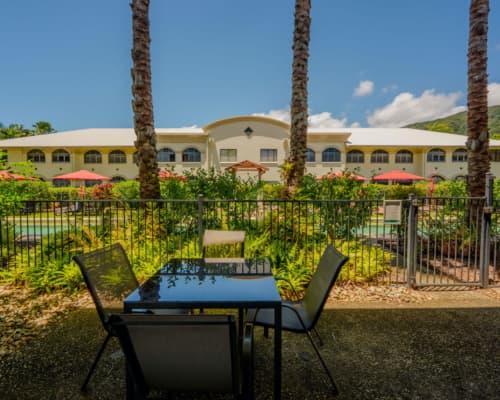 Dining setting in a shady courtyard of a 1 or 2 bedroom apartment at Mango Lagoon Resort, Palm Cove Cairns, with access to the pool area
