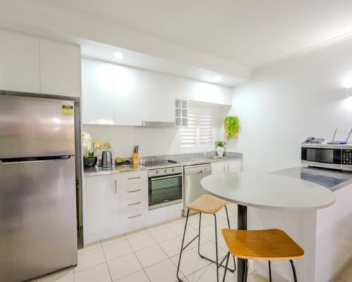Self-contained modern kitchen in an upper floor 1 or 2 bedroom apartment at Mango Lagoon Resort, Palm Cove Cairns, featuring fridge, oven, microwave, and dishwasher